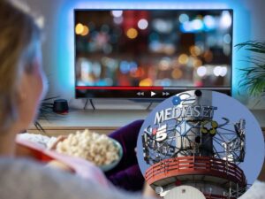antenne Mediaset e persona che guarda la tv cambiamento palinsesto